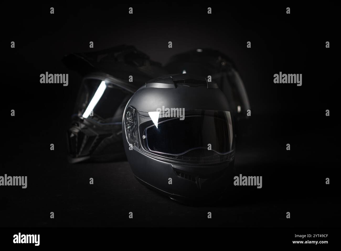 Schwarzer Motorradhelm auf schwarzem Hintergrund. Stockfoto
