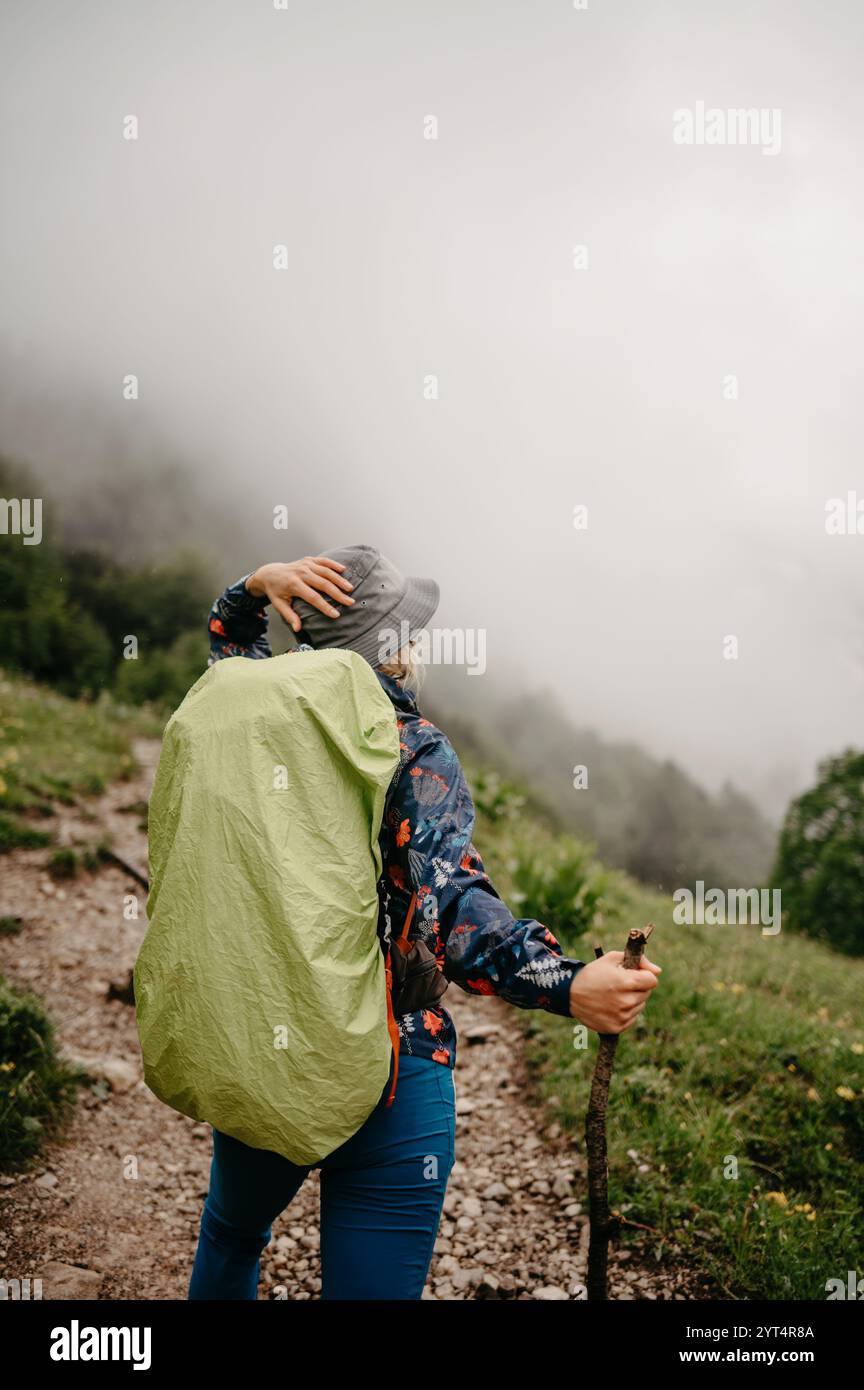 Wanderer in Regenjacke in der nebligen deutschen Alpenlandschaft Stockfoto