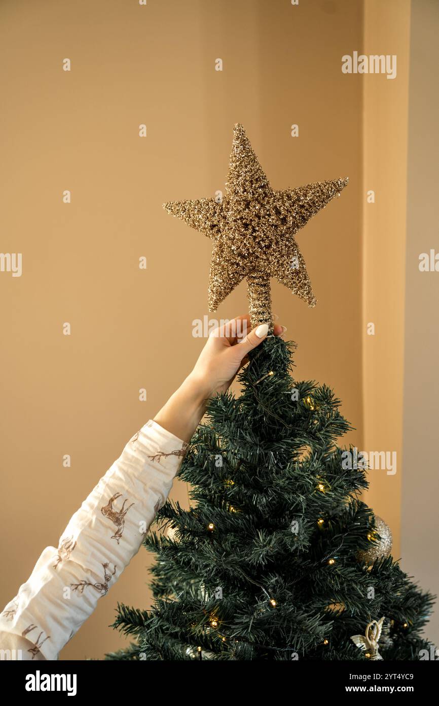 Den Weihnachtsbaum mit dem Stern dekorieren Stockfoto