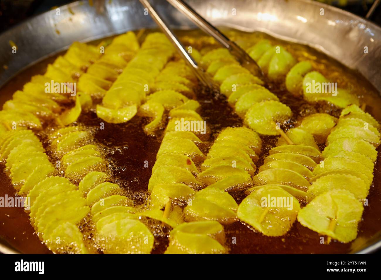 Gebratene gedrehte Kartoffelchips in der Pfanne Stockfoto