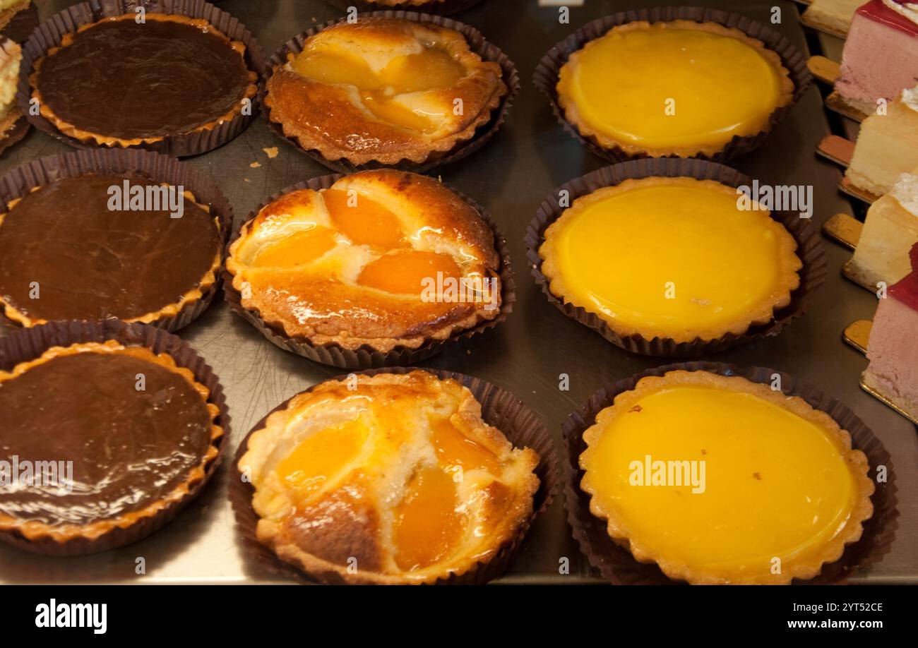 Traditionelles Brot und Kuchen Shop, Kunsthandwerk Bäckerei, St. Denis, Paris, Frankreich. Obst- und Schokoladentörtchen, kleine Kuchen, Eierflan-Kuchen Stockfoto