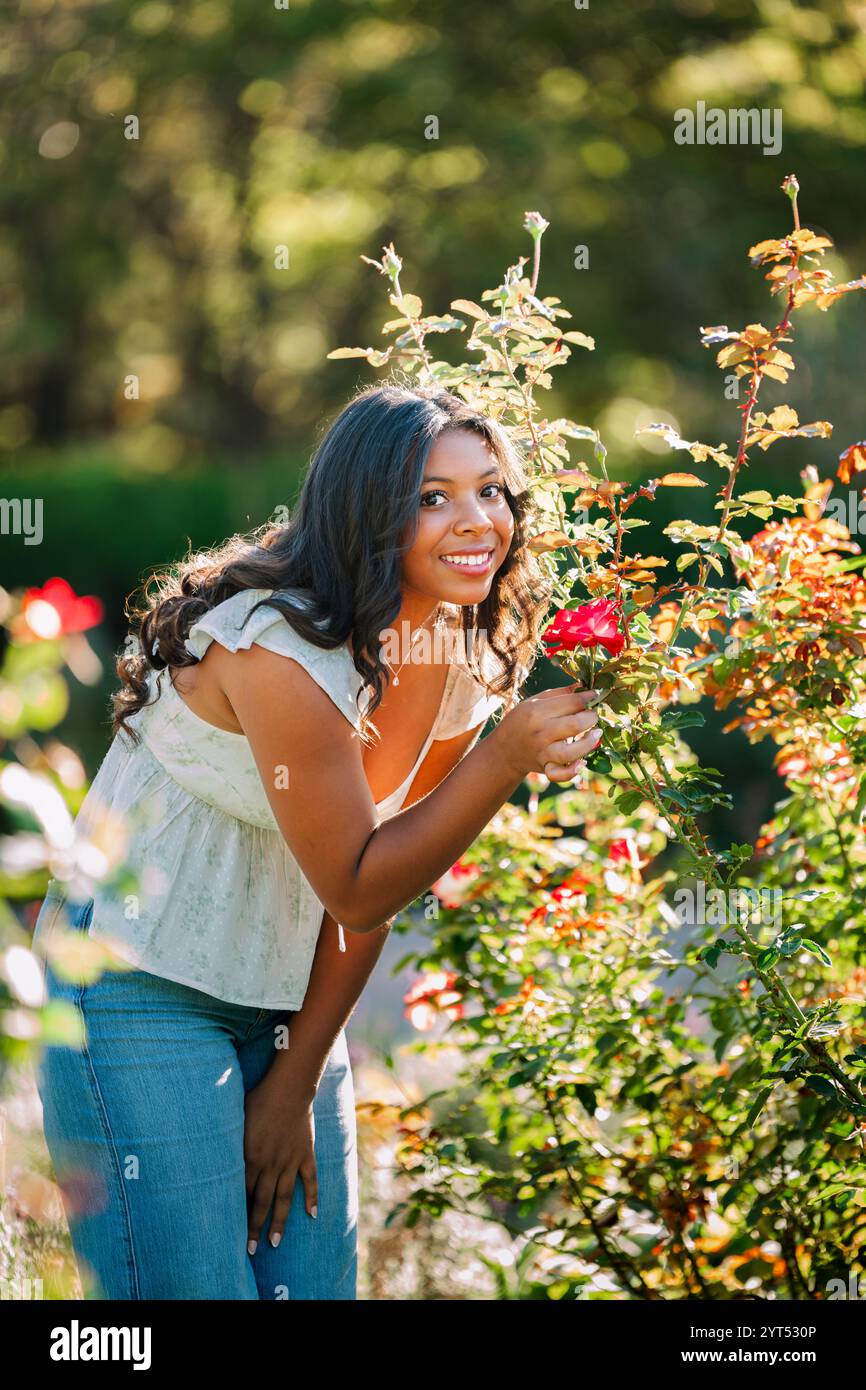 Model posiert in einem Garten mit einer Rose Stockfoto