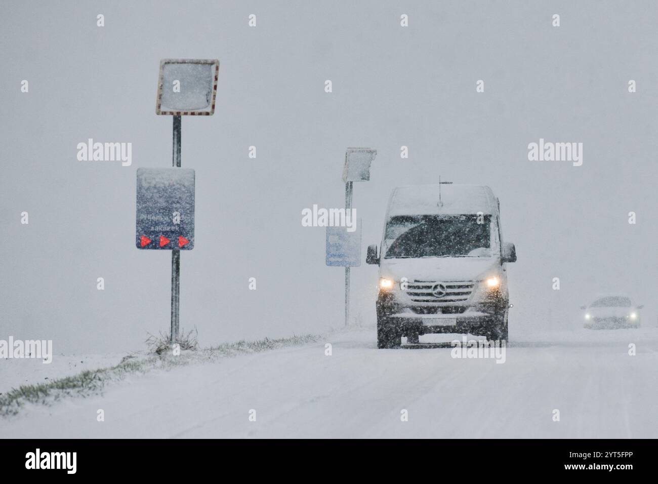 Brünn, Tschechische Republik. Dezember 2024. Intensiver Schneefall in Brünn und Umgebung am 6. Dezember 2024. In diesem Bild ein schneebedeckter konvexer Sicherheitsspiegel und ein vorbeifahrendes Auto. Quelle: Patrik Uhlir/CTK Photo/Alamy Live News Stockfoto