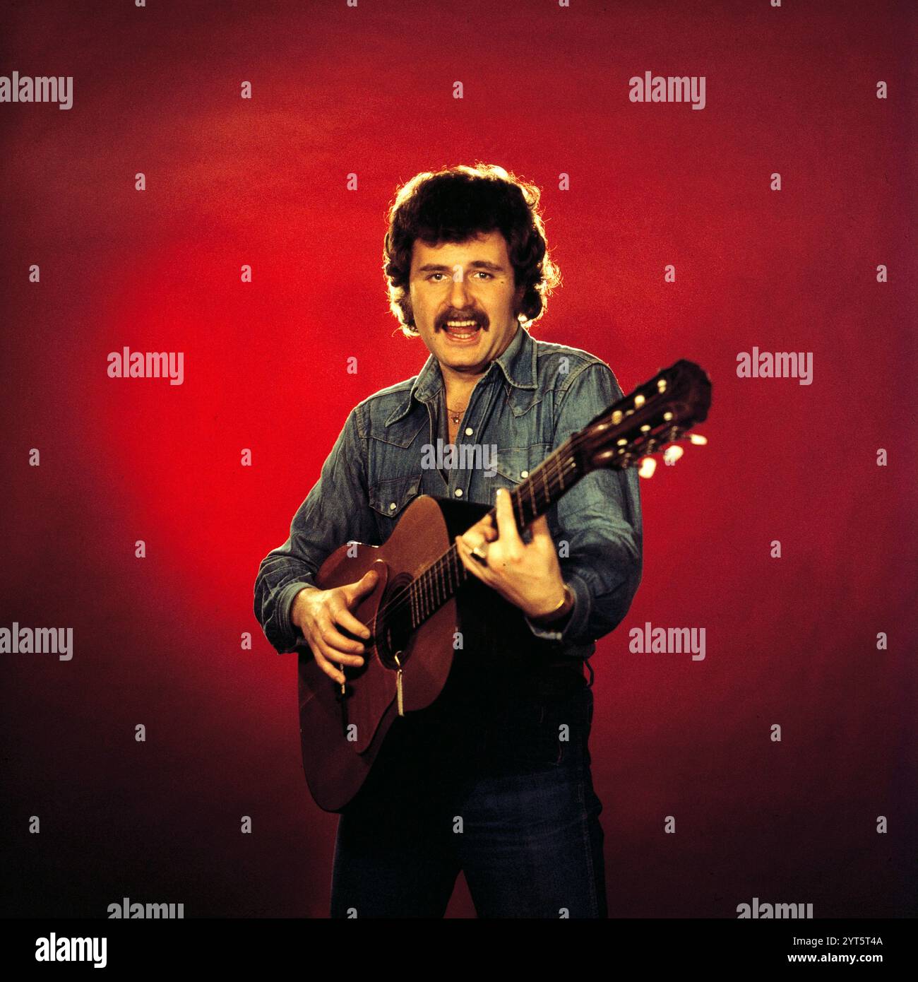 Der polnische Popsänger, Gitarrist und Songwriter Krzysztof Krawczyk im Porträt mit Gitarre beim Fotoshooting im Fotostudio von Tassilo Leher in Ost-Berlin für das Album-Cover seines Alben 'Rysunek na Szkle', DDR 1976. Stockfoto