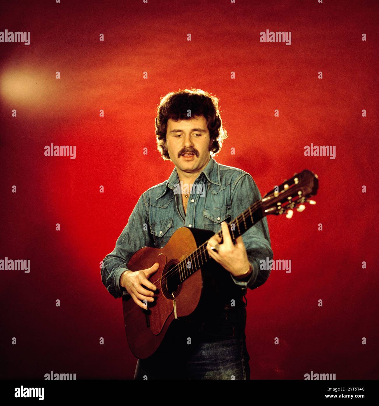 Der polnische Popsänger, Gitarrist und Songwriter Krzysztof Krawczyk im Porträt mit Gitarre beim Fotoshooting im Fotostudio von Tassilo Leher in Ost-Berlin für das Album-Cover seines Alben 'Rysunek na Szkle', DDR 1976. Stockfoto