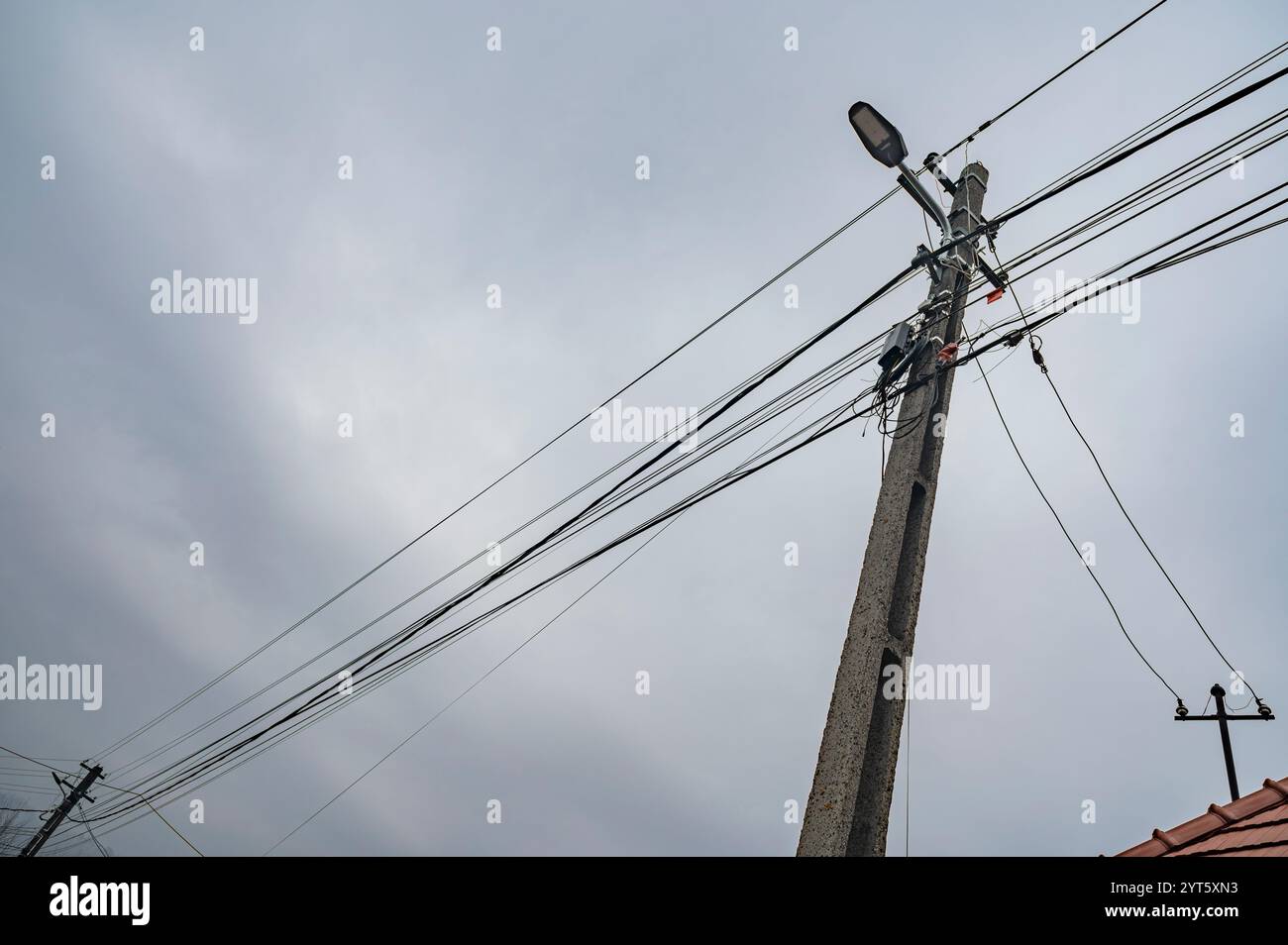 Strommasten mit vielen Kabeln an einem bewölkten Tag. Stockfoto