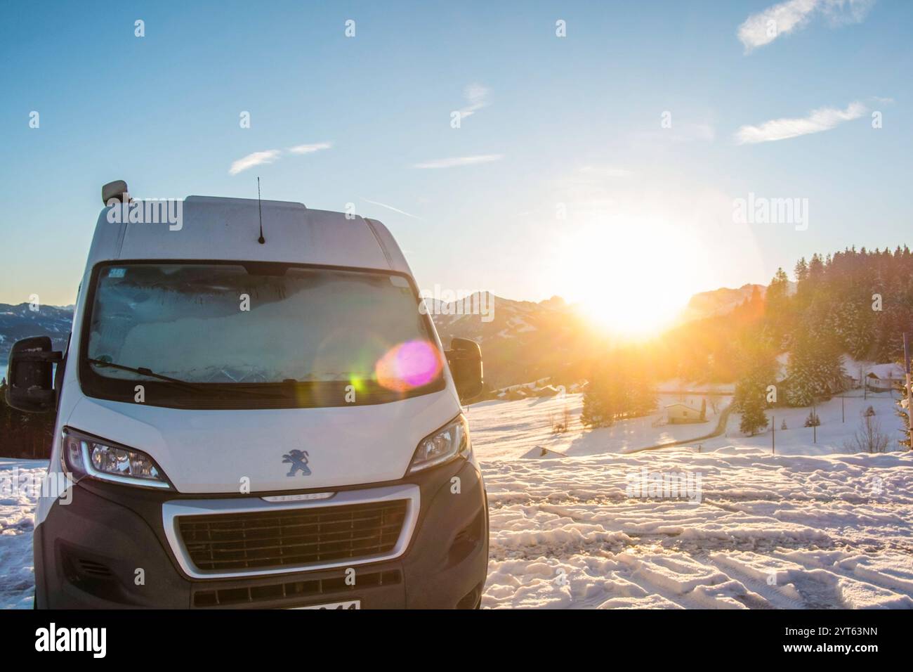 Ein Camper steht im Winter auf einem Parkplatz in den Alpen bei Sonnenaufgang im Schnee. Bödele, Vorarlberg, Österreich Winter in den Österreichischen Alpen *** Ein Wohnmobil steht auf einem Parkplatz in den Alpen im Winter bei Sonnenaufgang im Schnee Bödele, Vorarlberg, Österreich Winter in den Österreichischen Alpen Stockfoto