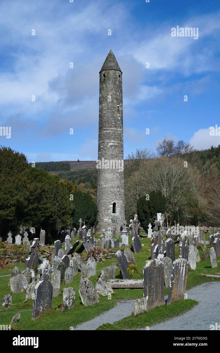 Rundturm und Friedhof des ehemaligen mittelalterlichen Klosters in Glendalough, Irland Stockfoto