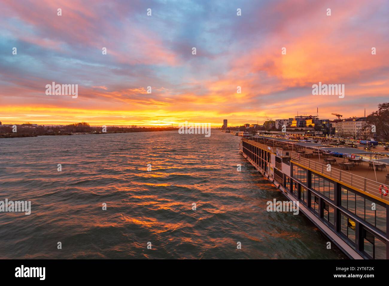 Wien: Sonnenaufgang auf der Donau, Kreuzfahrtschiffe an der Reichsbrücke, Weihnachtsdekoration 02. Leopoldstadt, Wien, Österreich Stockfoto