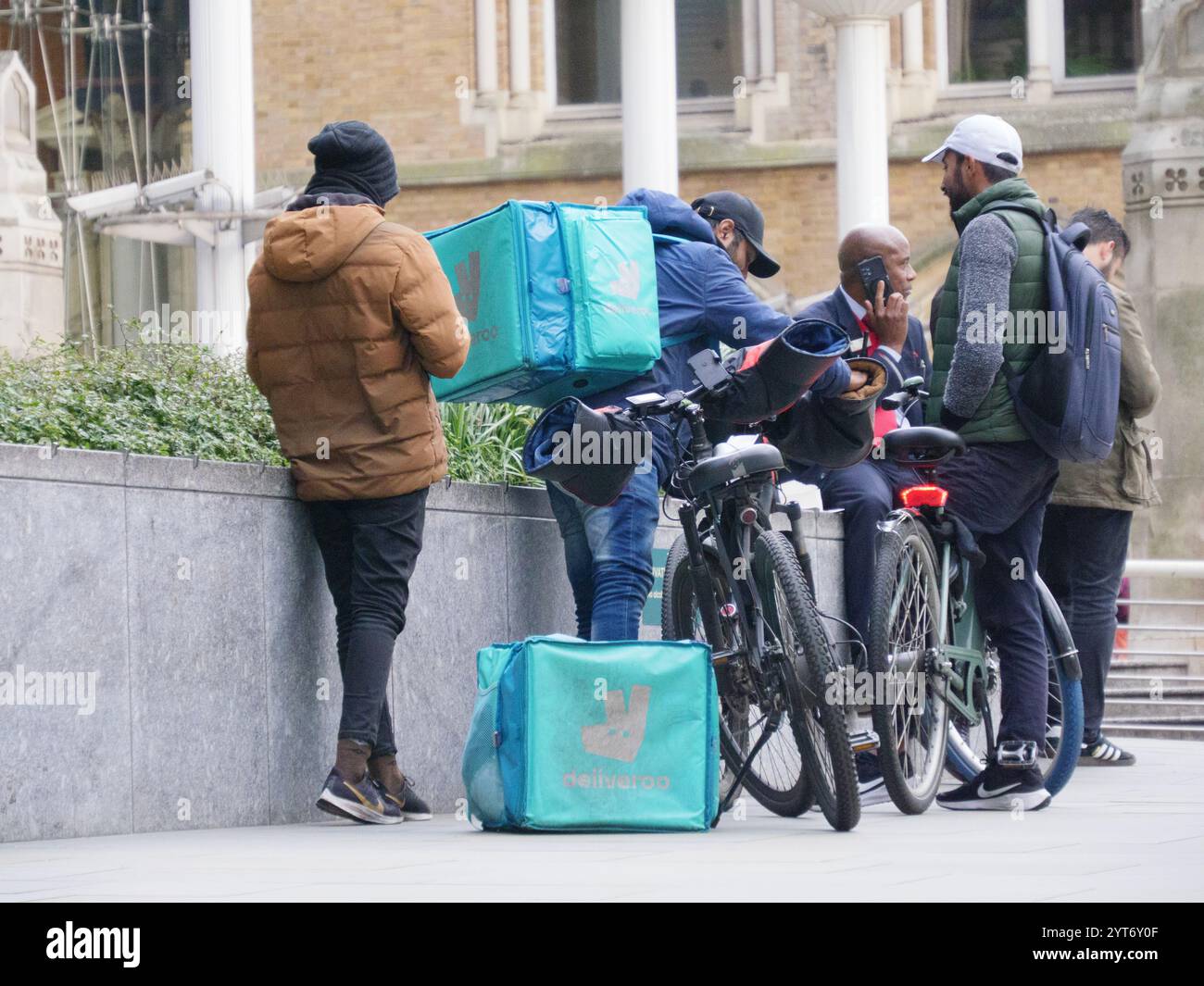 Deliveroo Lieferfahrer vor der Liverpool Street Station, London, mit elektrischem E-Bike Stockfoto