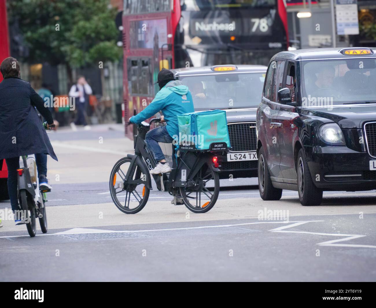 Deliveroo Lieferfahrer auf Port E-Bike im Verkehr in der Nähe der Liverpool Street Station London Stockfoto
