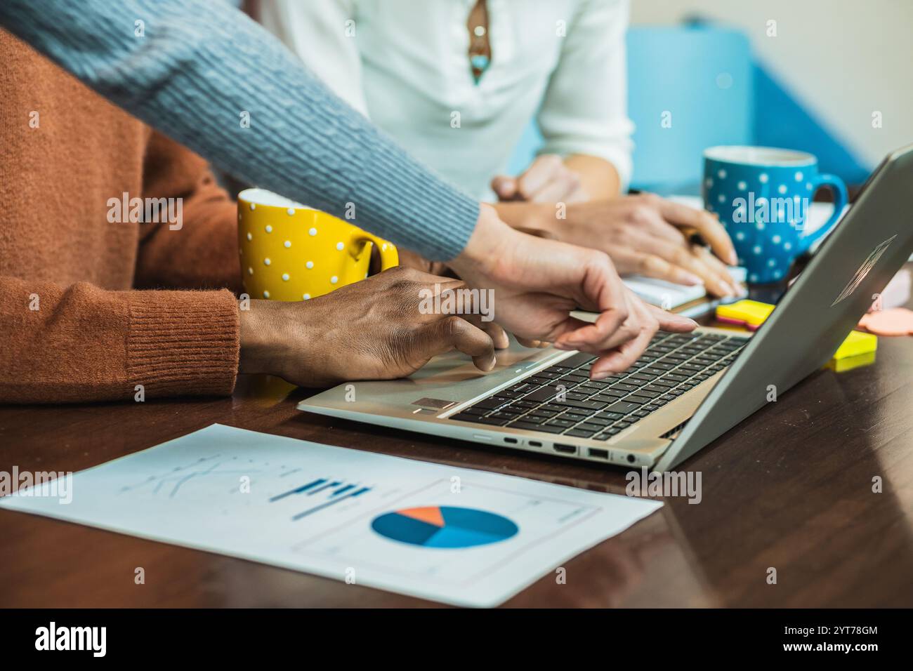 Geschäftsteam arbeitet an einem Laptop zusammen und analysiert Finanzdaten in einem Meeting Stockfoto