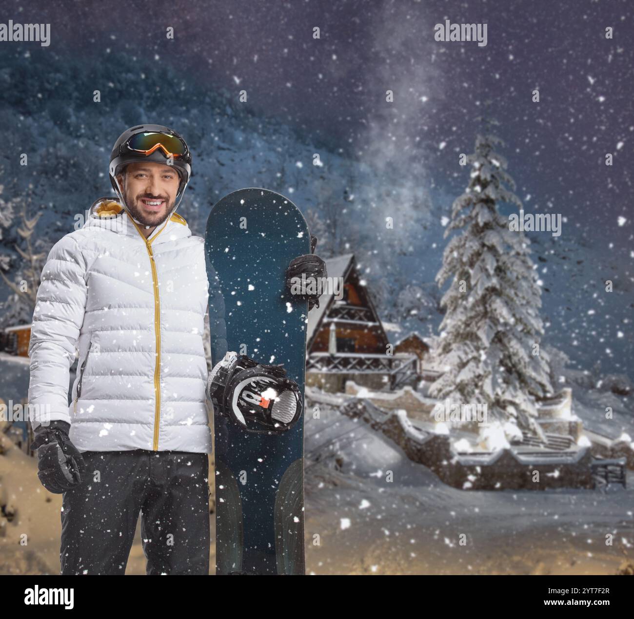 Mann mit Snowboard in einer verschneiten Bergnacht Stockfoto