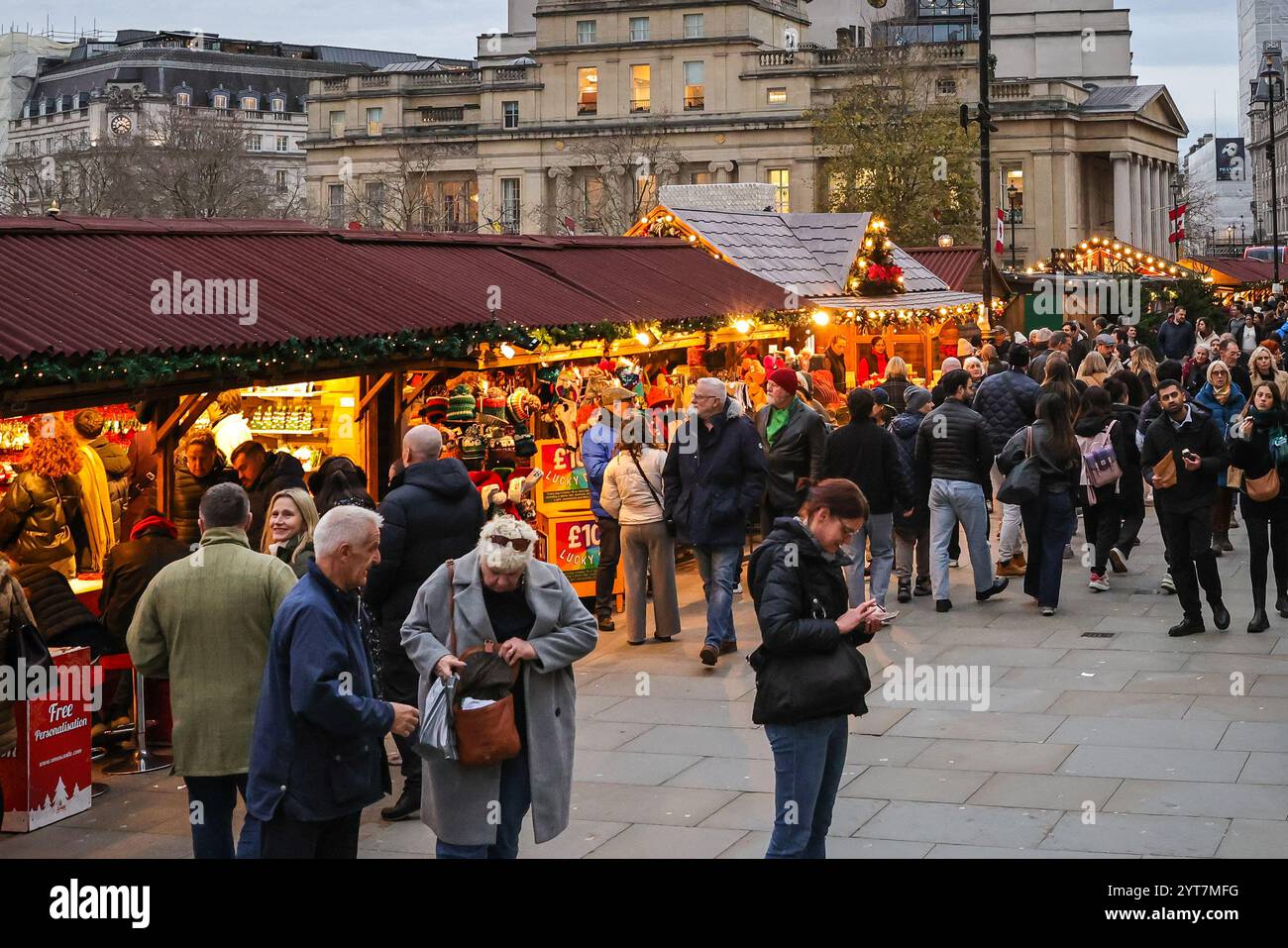 London, Großbritannien. Dezember 2024. Touristen und Besucher schlendern entlang der vielen festlichen Geschenke-, Speise- und Getränkestände am Trafalgar Square Weihnachtsmarkt am Nikolaustag, auch Nikolaustag genannt. Der 6. Dezember wird in vielen westlichen christlichen Ländern gefeiert, um den Heiligen Nikolaus von Myra zu ehren, einen Bischof, der den Ruf hat, ein großzügiger Geschenk zu sein. Quelle: Imageplotter/Alamy Live News Stockfoto