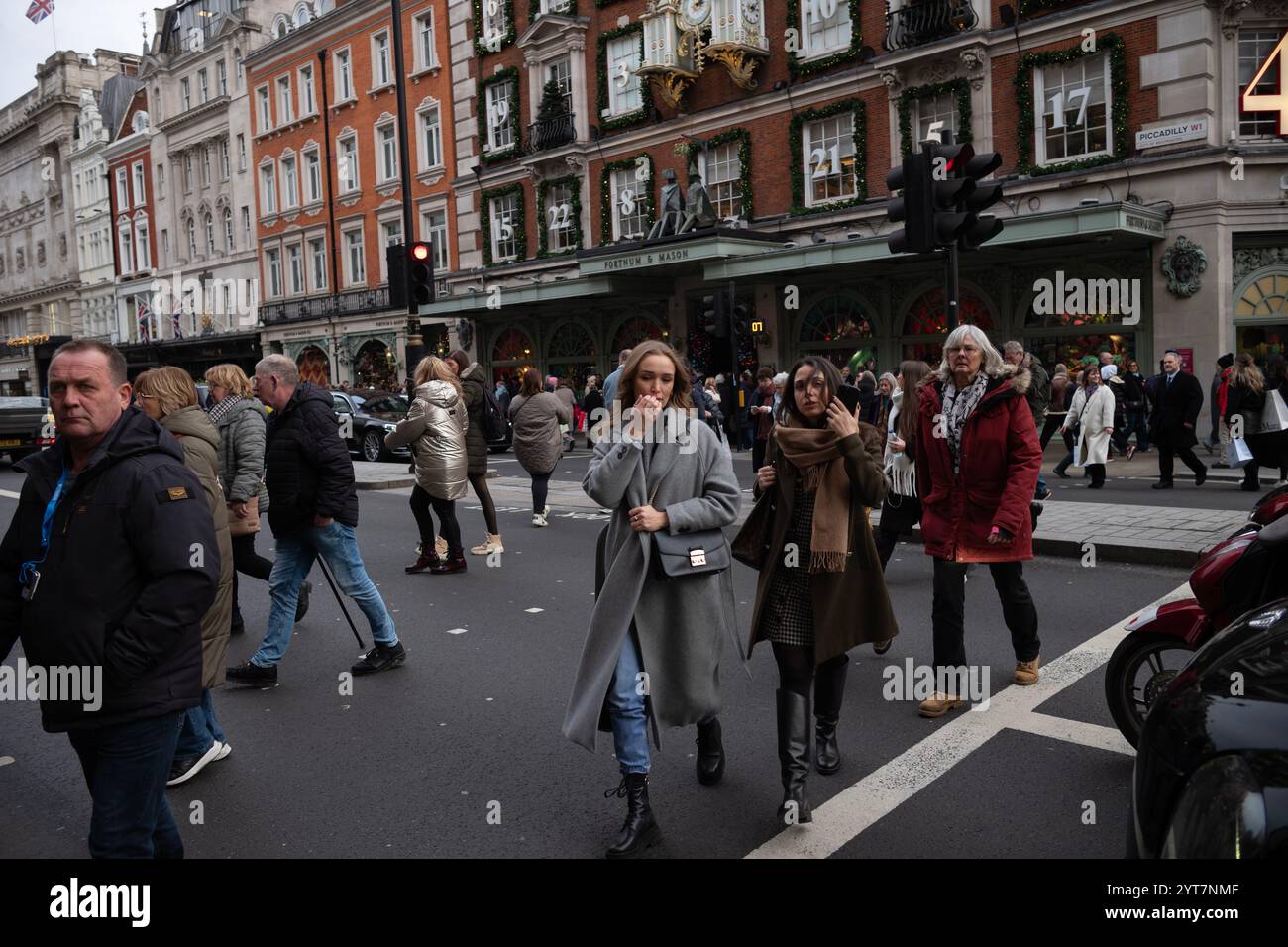 Fußgänger überqueren die Straße gegenüber dem luxuriösen Kaufhaus Fortnum & Mason, das sich in Piccadilly befindet, einem der reichsten Viertel Londons, England Stockfoto Fußgänger überqueren die Straße gegenüber dem luxuriösen Kaufhaus Fortnum & Mason, das sich in Piccadilly befindet, einem der reichsten Viertel Londons, England Stockfoto