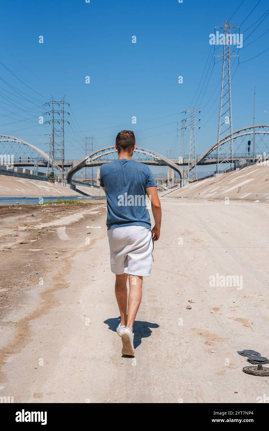 Person, die am Los Angeles River mit Sixth Street Viaduct vorbeiläuft Stockfoto