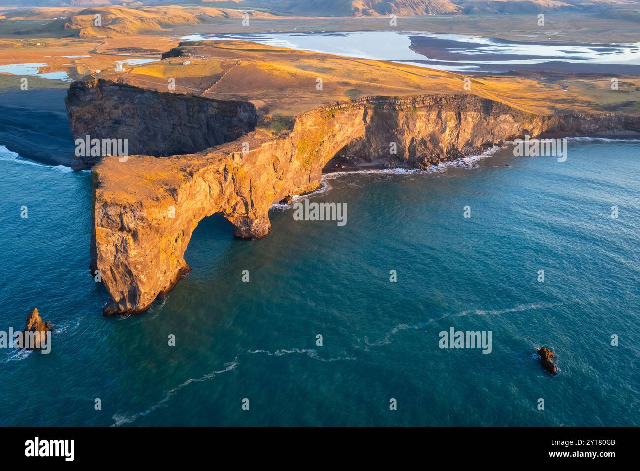 Blick aus der Vogelperspektive auf den Dyrholaey-Bogen und die Klippe bei Sonnenaufgang. V'k ' Myrdal, Südisland, Island, Nordeuropa. Stockfoto