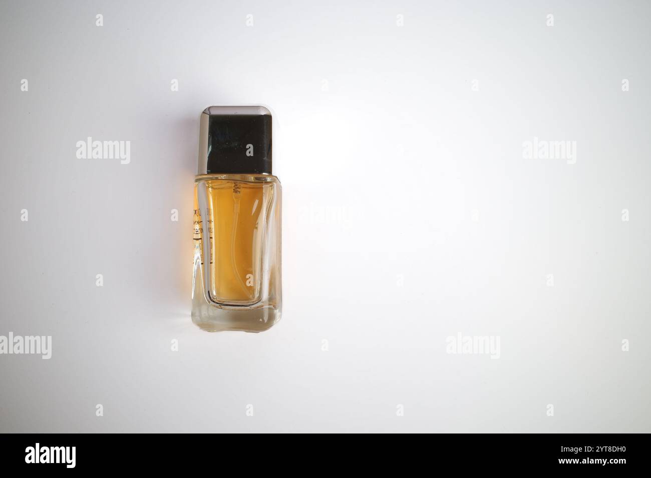 Minimalistische Parfümflasche mit schwarzer Kappe auf weißem Hintergrund Stockfoto