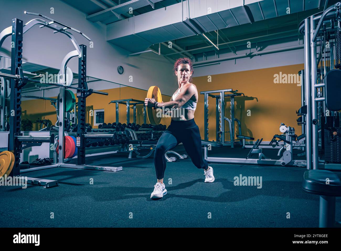 Junge Frau, die im Fitnessraum oder Fitnessraum trainiert Stockfoto