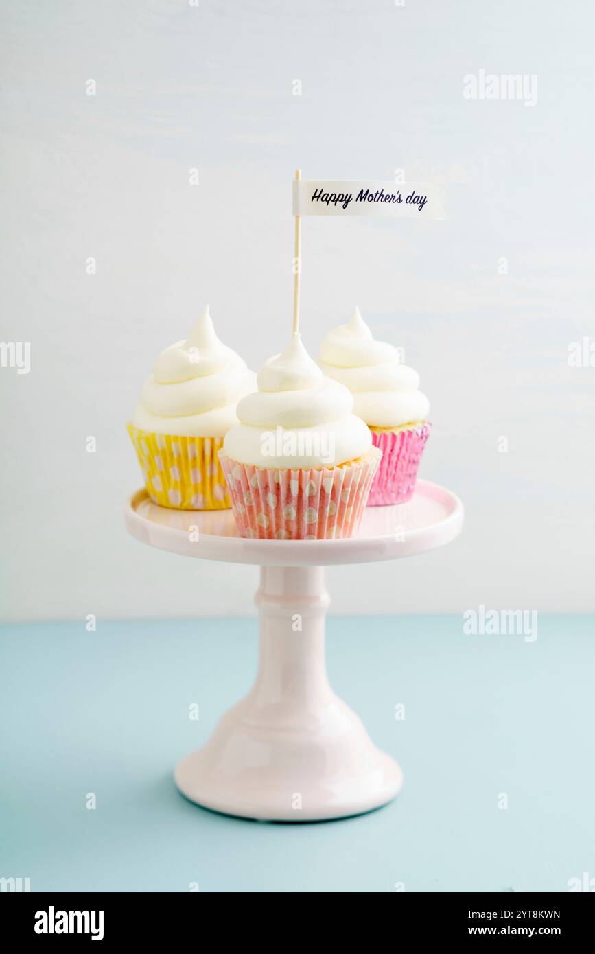 Drei Cupcakes zum Muttertag mit Buttercreme auf einem Kuchenständer Stockfoto