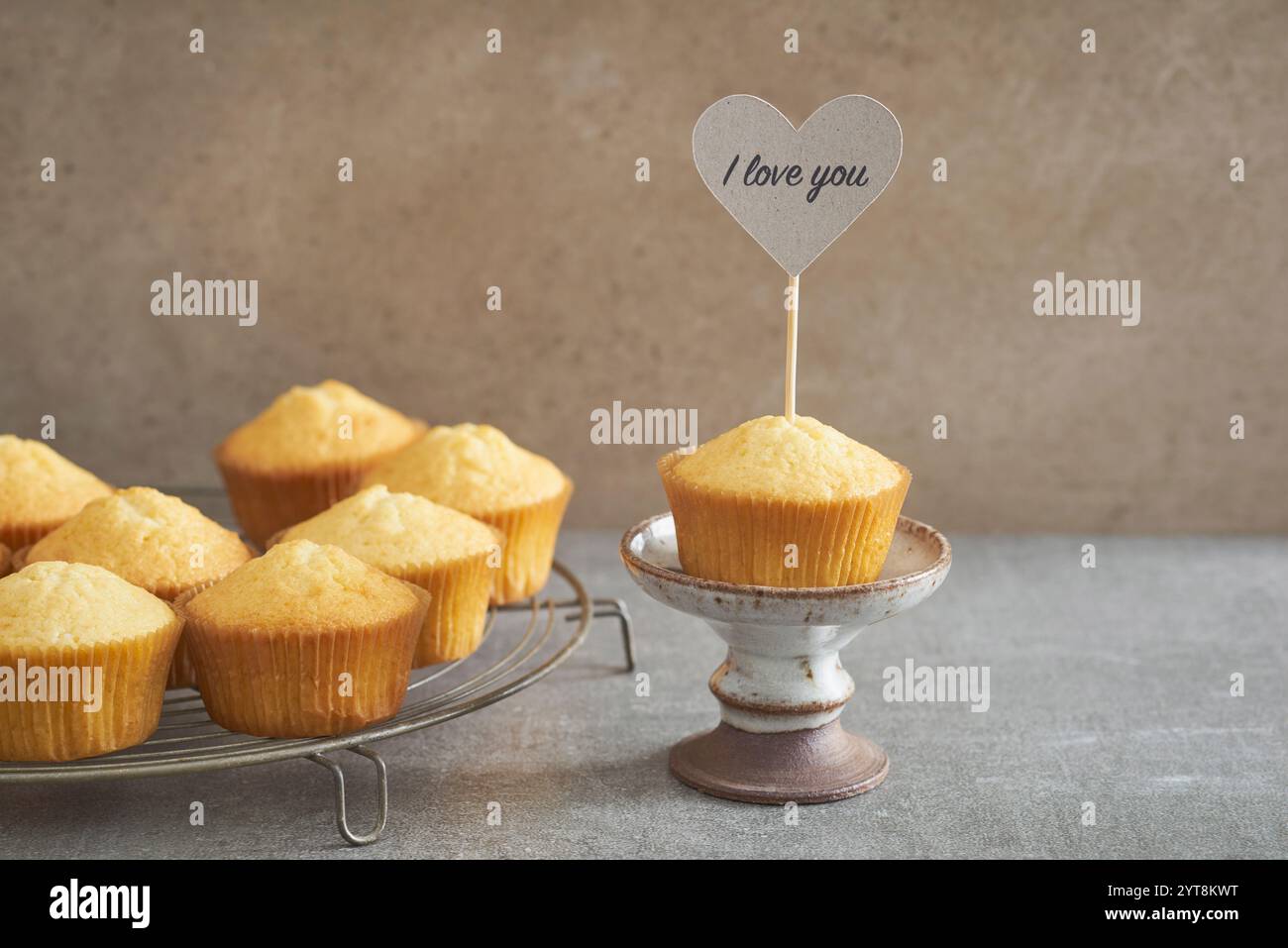 Vanille-Cupcake mit Liebeserklärung auf einem rustikalen Kuchenständer Stockfoto