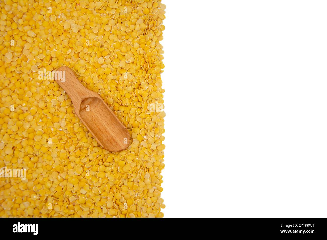 Gelber Linsenhaufen mit Holzlöffel, halber weißer Kopierraum Stockfoto