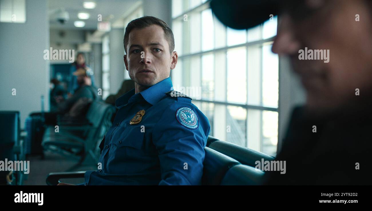 ERSCHEINUNGSDATUM: 13. Dezember 2024. TITEL: Handgepäck. STUDIO: Netflix. DIREKTOR: Jaume Collet-Serra. PLOT: Ein mysteriöser Reisender erpresst einen jungen TSA-Agenten, damit er ein gefährliches Paket durch die Sicherheitskontrolle und auf einen Flug am Weihnachtsfeiertag rutschen lässt. TARON EGERTON als Ethan Kopek, JASON BATEMAN als Traveler. (Credit Image: © Netflix/Entertainment Pictures/ZUMAPRESS.com) NUR REDAKTIONELLE VERWENDUNG! Nicht für kommerzielle ZWECKE! Stockfoto