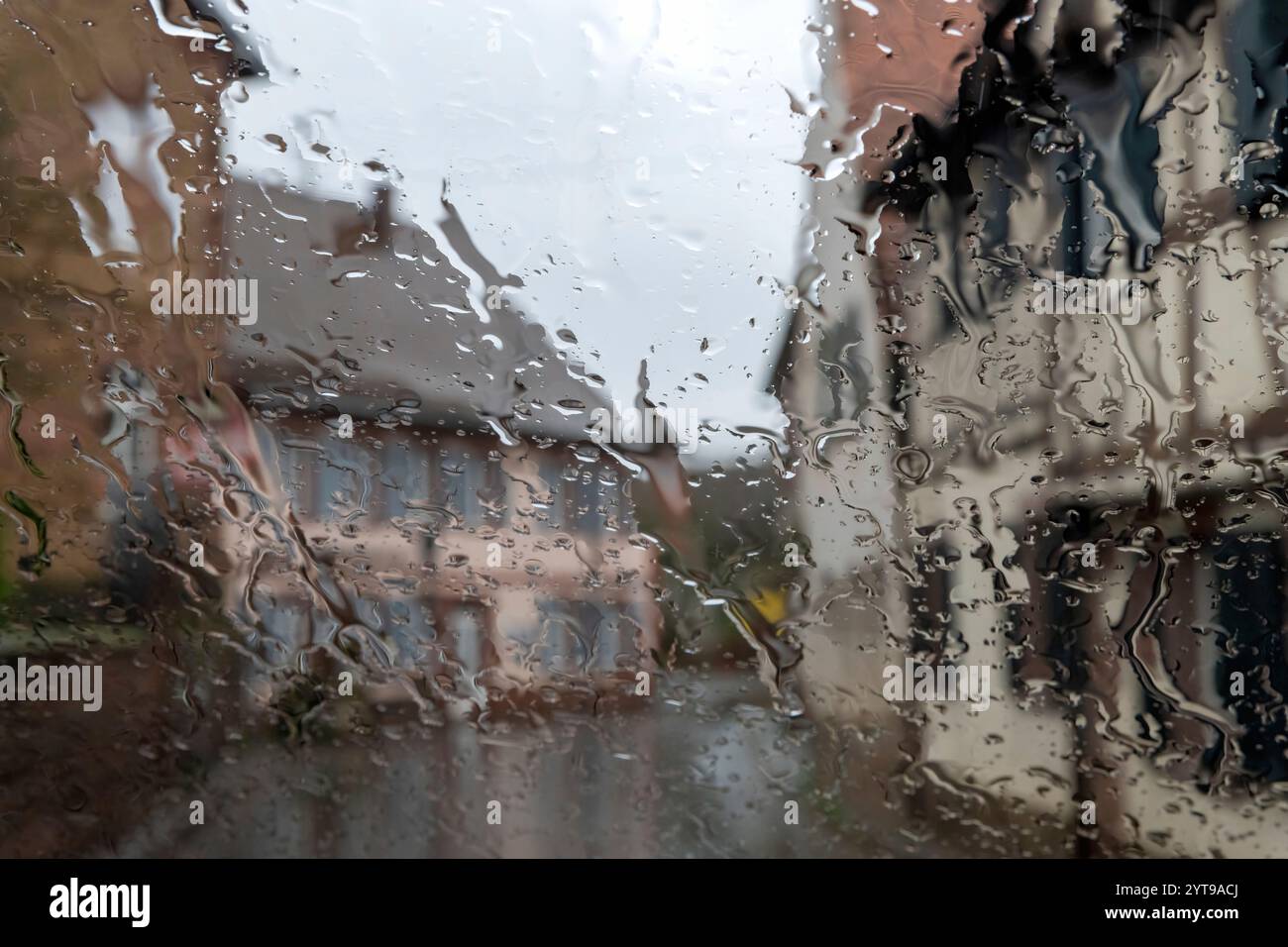 Regentropfen auf dem Glas, verschwommener Hintergrund. Regenwetter. Stockfoto