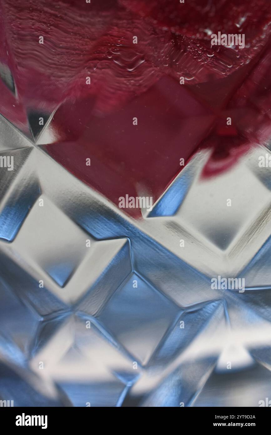 Dunkelrot, blau und Luftblasen im Wasser hinter geschliffenem Glas Stockfoto