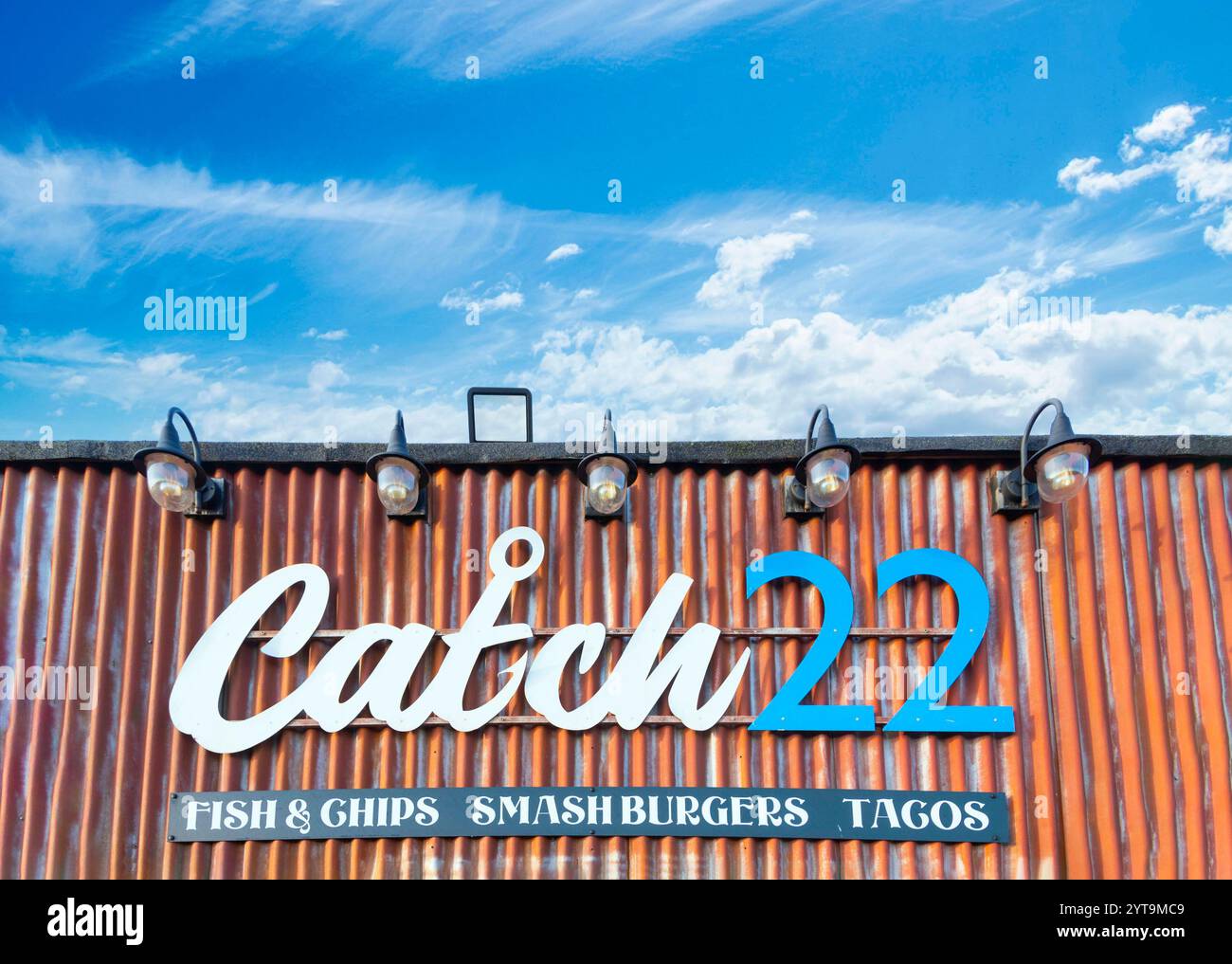 Rustikales Restaurantschild für Catch 22 mit Fish and Chips, zertrümmerten Burgern und Tacos vor einem blauen Himmel mit schimmernden Wolken sunderland Stockfoto