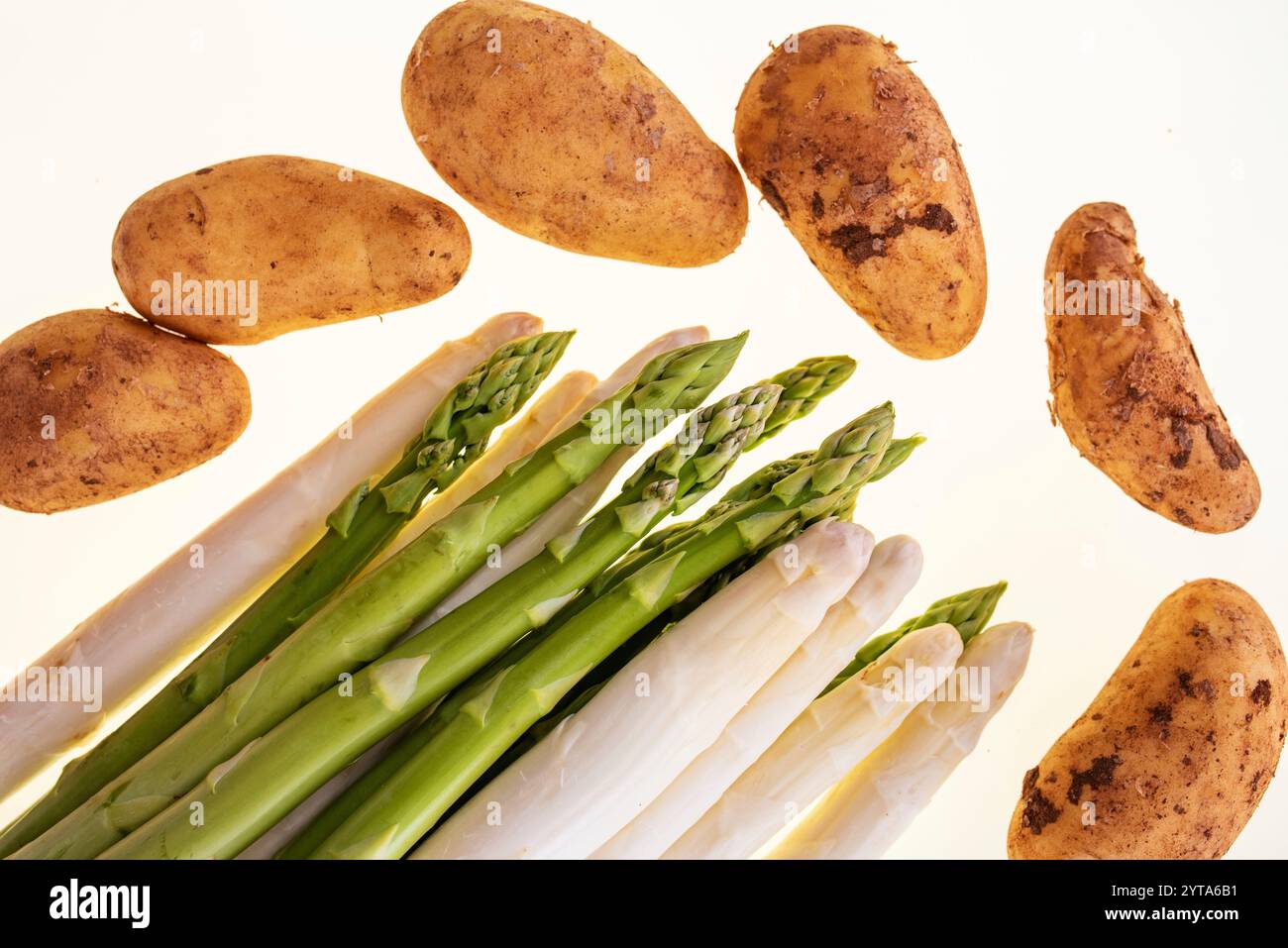 Frischer weißer und grüner Spargel mit Kartoffeln isoliert auf weißem Hintergrund. Draufsicht auf Frühlingsgemüse. Hintergrund für gesunde Ernährung und saisonale Gastronomie. Stockfoto