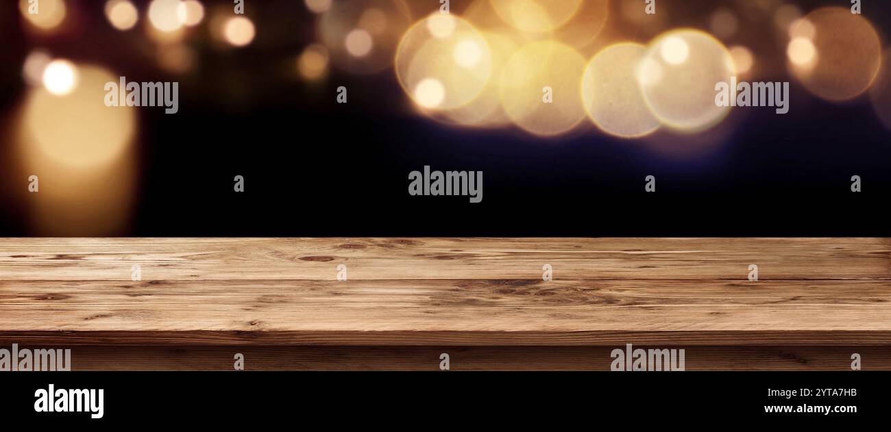 Dunkle Panorama mit golden leuchtet vor einem leeren Tisch für ein Konzept Stockfoto