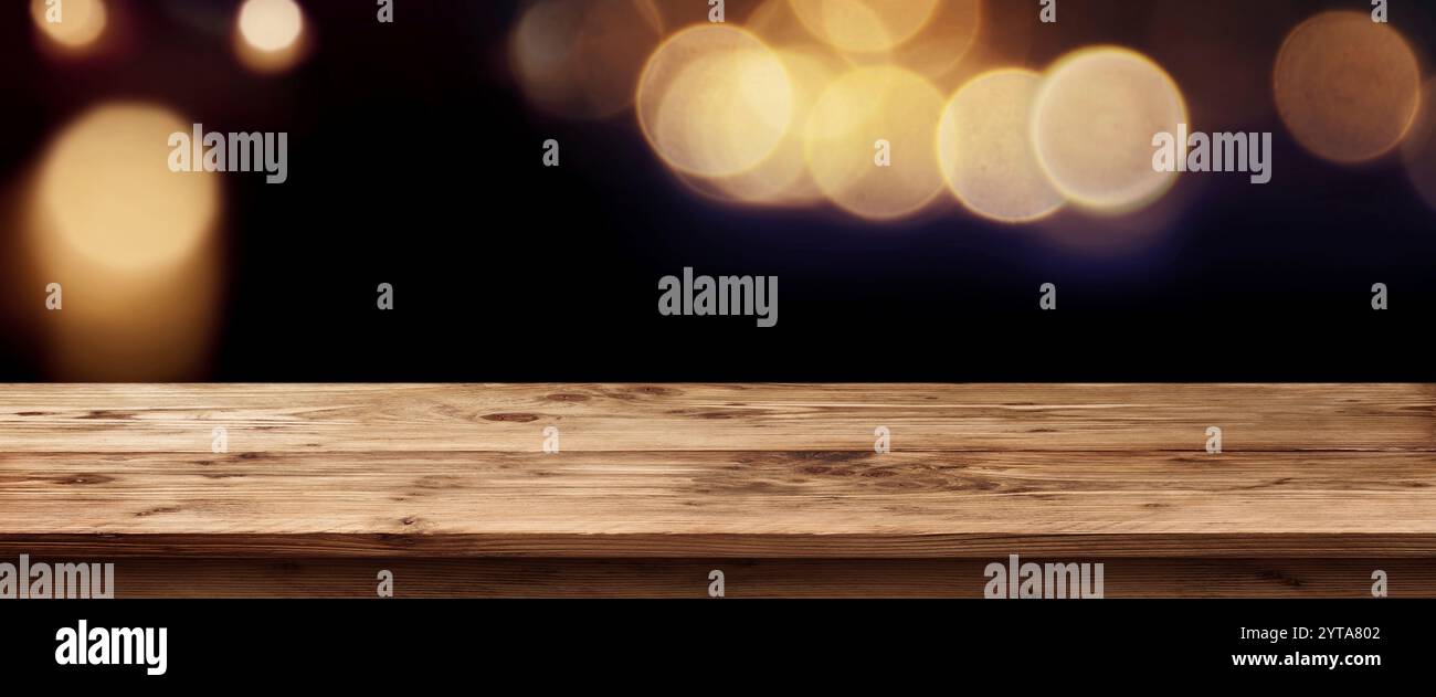 Dunkle Panorama mit goldenem Licht für Feiertage vor einem leeren Tisch für ein Konzept Stockfoto