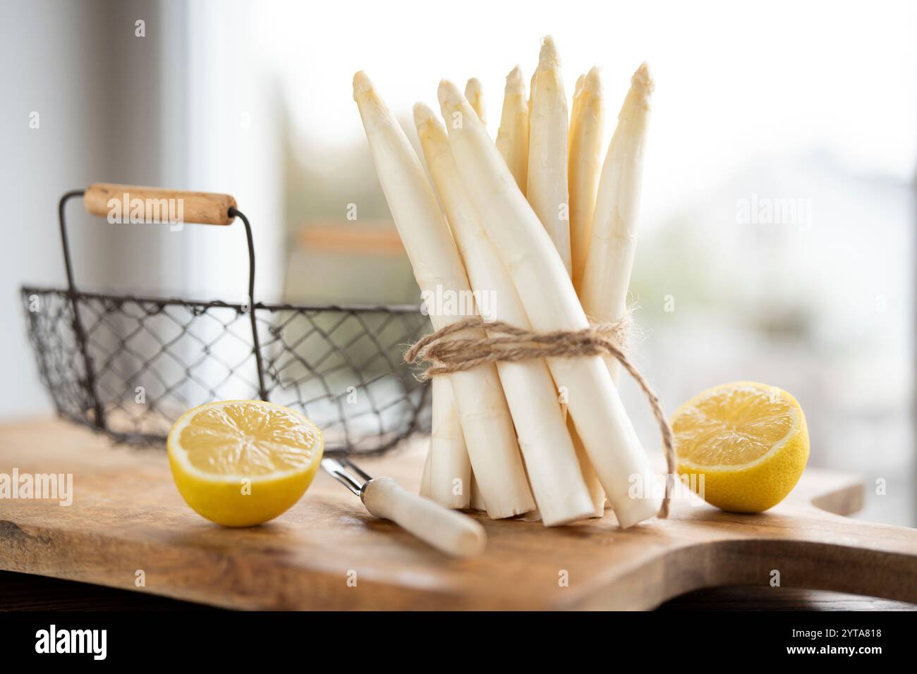 Stehende Haufen frischer weißer Spargel. Saisonales Frühlingsgemüse mit Zitrone auf hölzernem Schneidebrett. Küche für die saisonale Gastronomie. Stockfoto