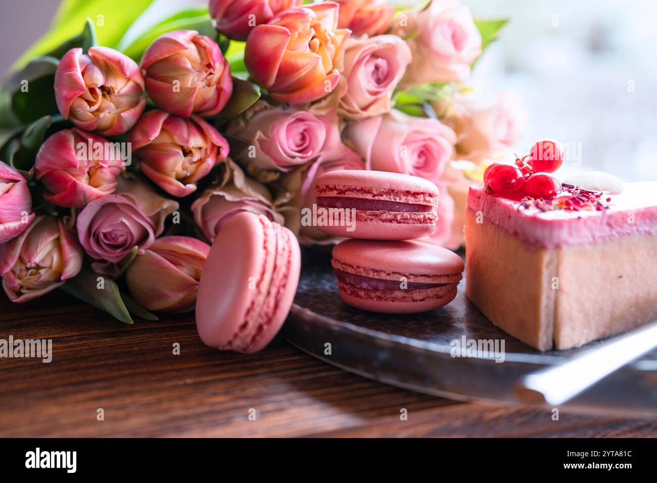 Köstlicher Dessertkuchen und rosafarbene Tulpen für den romantischen Muttertag am Morgen. Nahaufnahme. Stockfoto