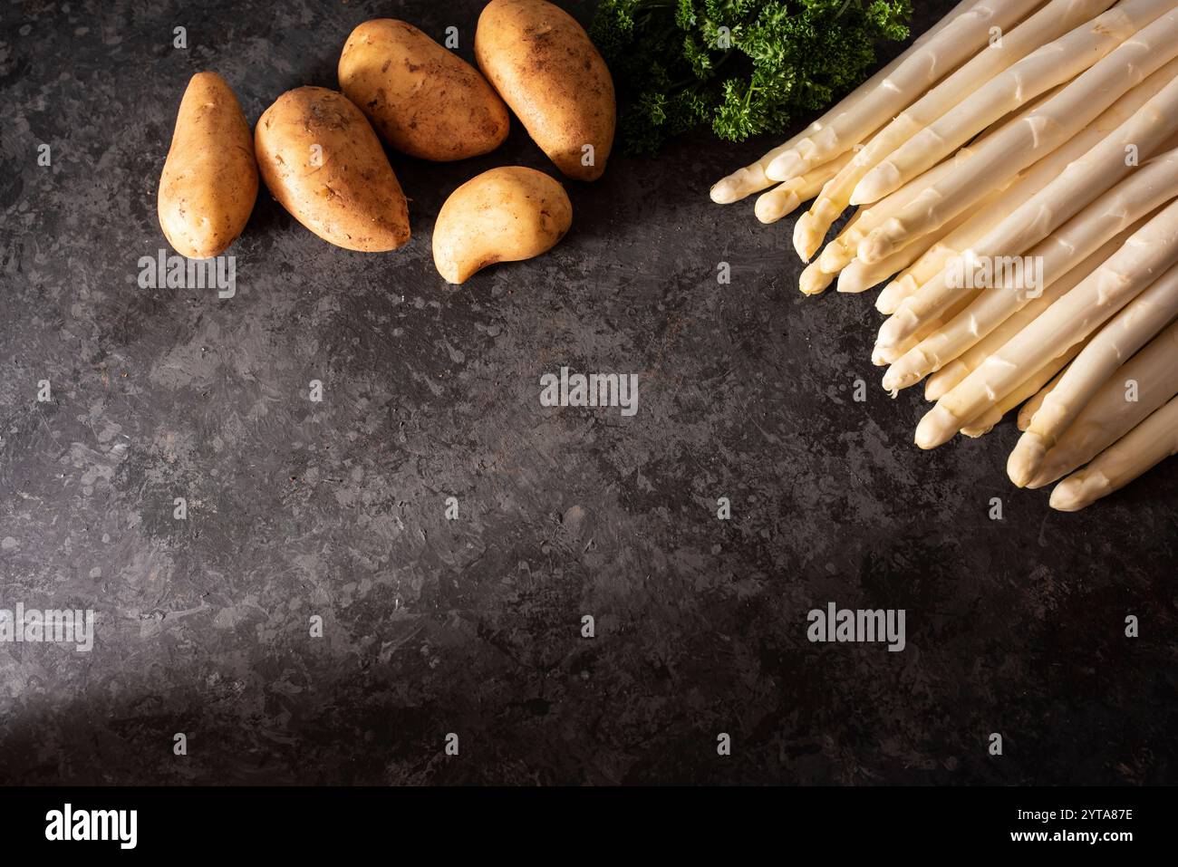Saisonal weißer Spargel und frische Zutaten auf schwarzem Schiefer. Hintergrund für gesundes Nährstoffkonzept mit Textraum. Stockfoto