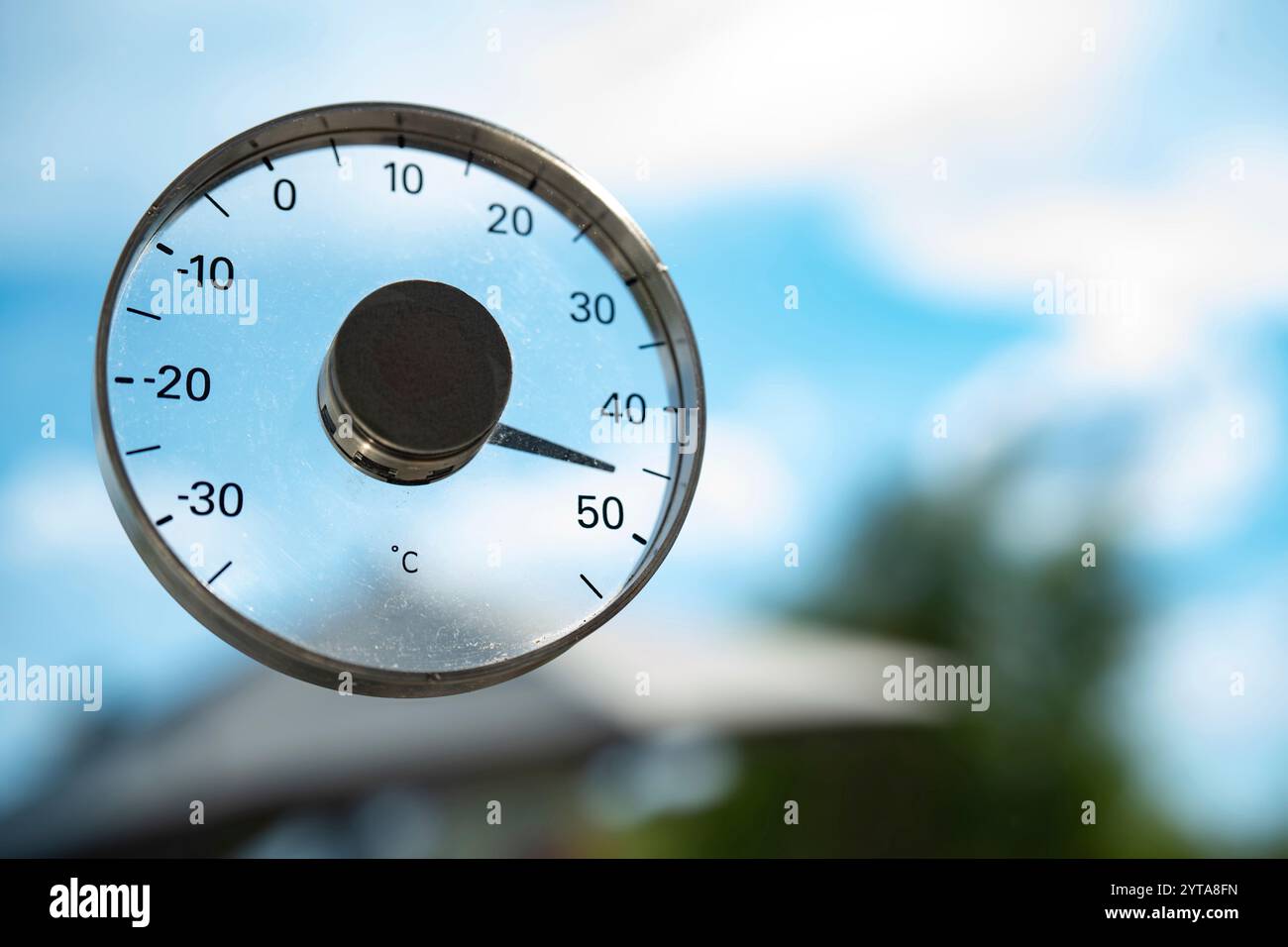 Heißer Sommertag mit 45 Grad und blauem Himmel. Saisonaler Hintergrund mit Thermometer. Hitzewelle. Nahaufnahme mit kurzer Schärfentiefe. Stockfoto
