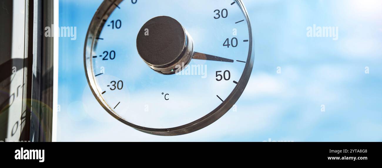 Heißer Sommertag mit 45 Grad und blauem Himmel. Saisonaler Hintergrund mit Thermometer. Hitzewelle. Nahaufnahme mit kurzer Schärfentiefe. Stockfoto