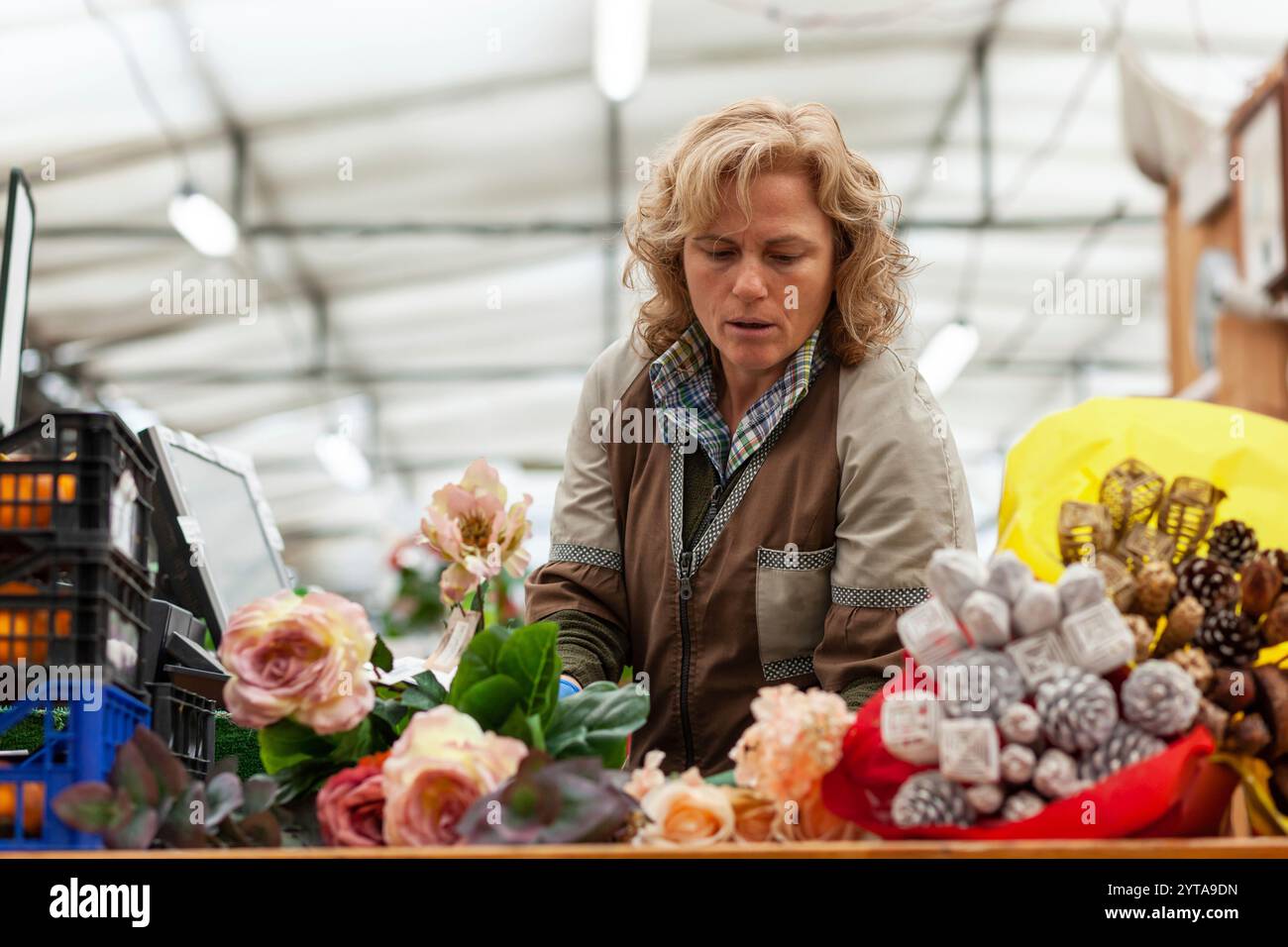 Florist mit Berufskleidung in einem Kindergarten-Konzept der Blumenarbeit Stockfoto