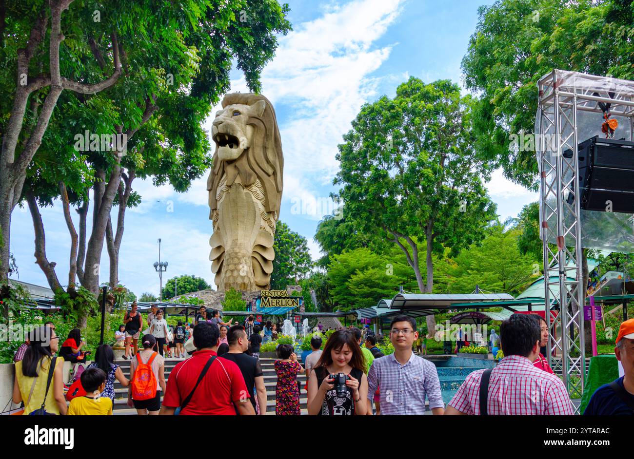 Besucher bewundern die majestätische Sentosa Merlion Statue inmitten des lebendigen Grüns und der lebhaften Atmosphäre auf Sentosa Island, Singapur. Stockfoto