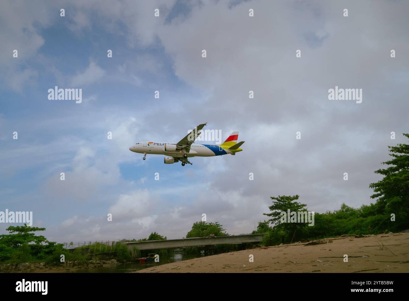 Ein kommerzielles Jet-Flugzeug fliegt tief über dem Strand von Balikpapan, während es landet, am 10. Oktober 2024 in Ostkalimantan, Indonesien Stockfoto