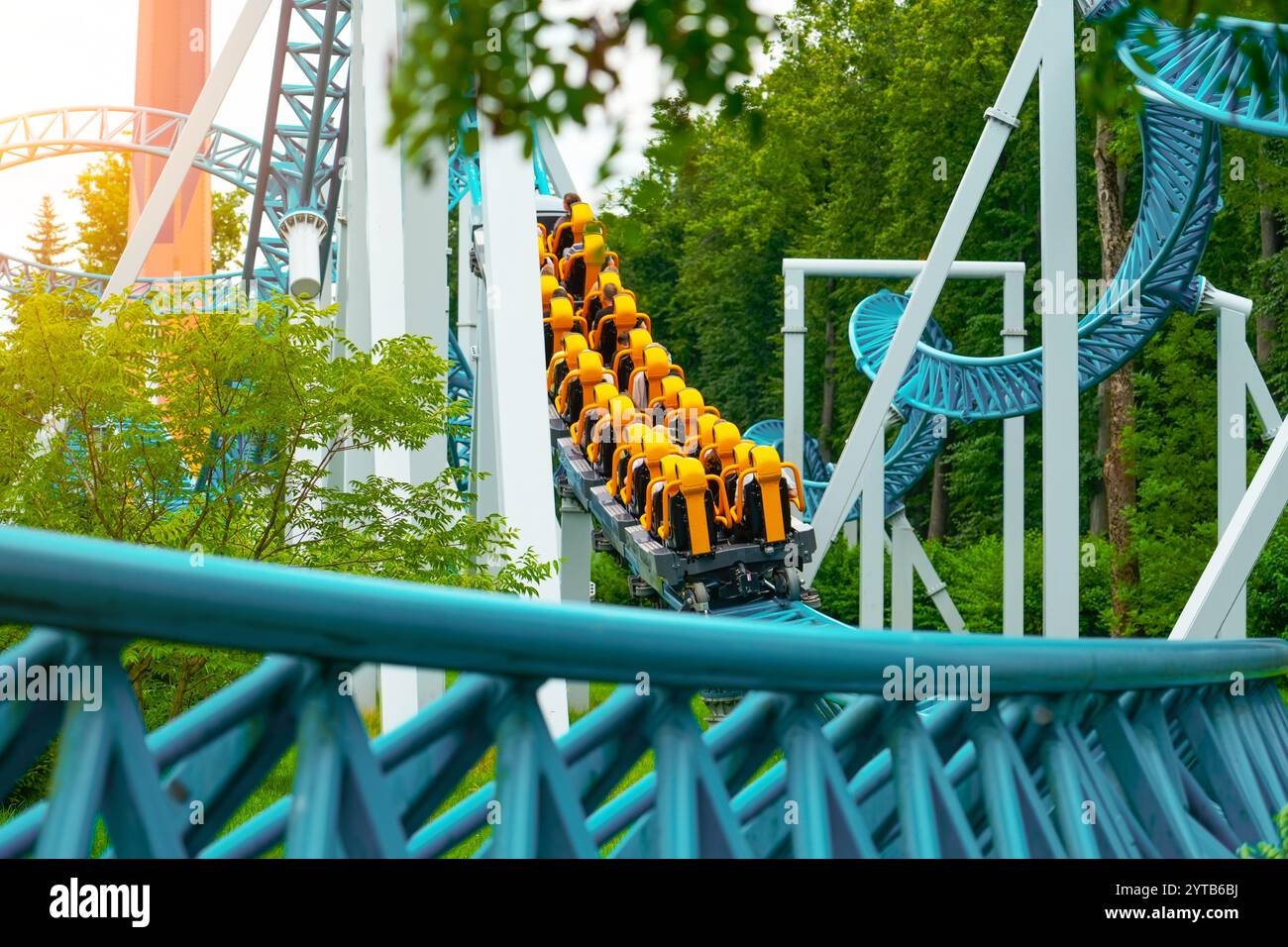 Loop Achterbahn in einem Vergnügungspark. Achterbahnwagen mit Leuten, die fahren, geht durch einen Spiralkorkenzieher, der in die Ferne zurückgeht Stockfoto