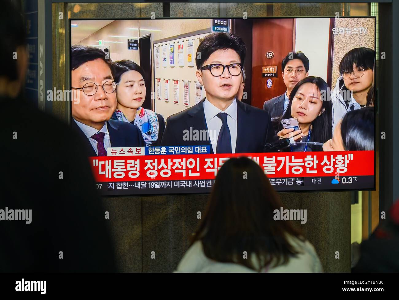 Eine 24-stündige Fernsehsendung von Yonhapnews am Bahnhof Yongsan zeigt Han Dong-hoon, den Führer der herrschenden People Power Party, mit Reportern vor der Nationalversammlung in Seoul. Der südkoreanische Präsident Yoon Suk Yeol sagte am 7. Dezember, dass er "aufrichtig bedauert" habe, dass er öffentliche Bedenken wegen der Ausrufung des Kriegsrechts Anfang dieser Woche geäußert habe, während er versprach, keinen weiteren solchen Versuch erneut zu Unternehmen. Präsident Yoon machte diese Bemerkung in seinem ersten öffentlichen Auftritt, nachdem er am 3. Dezember das Kriegsrecht ausgerufen hatte und sechs Stunden später, nachdem die Nationalversammlung dagegen gestimmt hatte, das Kriegsrecht annulliert hatte. "Ich werde nicht avoi Stockfoto