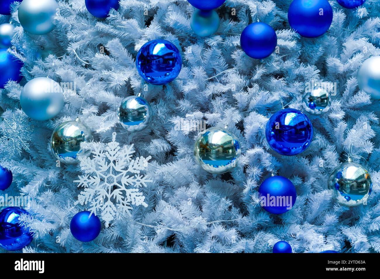 Weihnachtsbaum mit silbernem Neujahrsspielzeug, blauen und silbernen Kugeln, glühenden Schneeflocken. Stockfoto