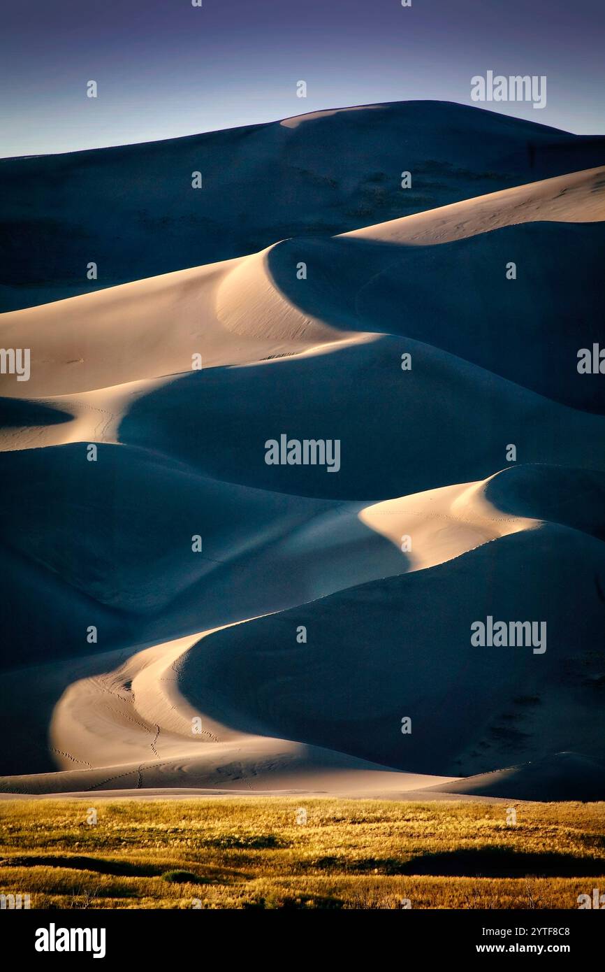 Geformt von den unerbittlichen Kräften von Wind und Zeit, sammelt sich Sand, der aus den umliegenden Ebenen getragen wird, am Fuße der Rocky Mountains an. Stockfoto