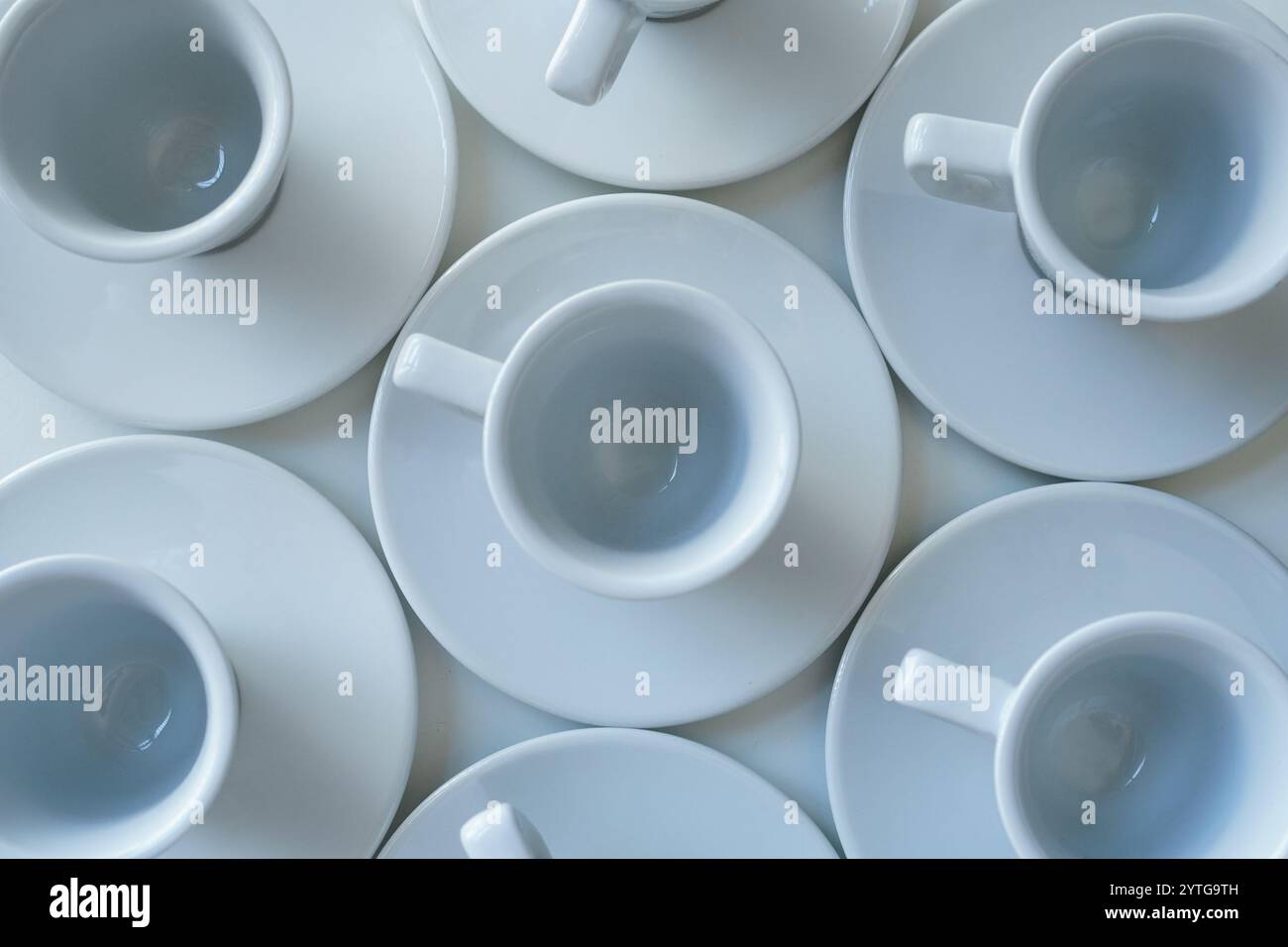 Weiße Kaffeetassen auf einem weißen Tisch, Blick von oben Stockfoto