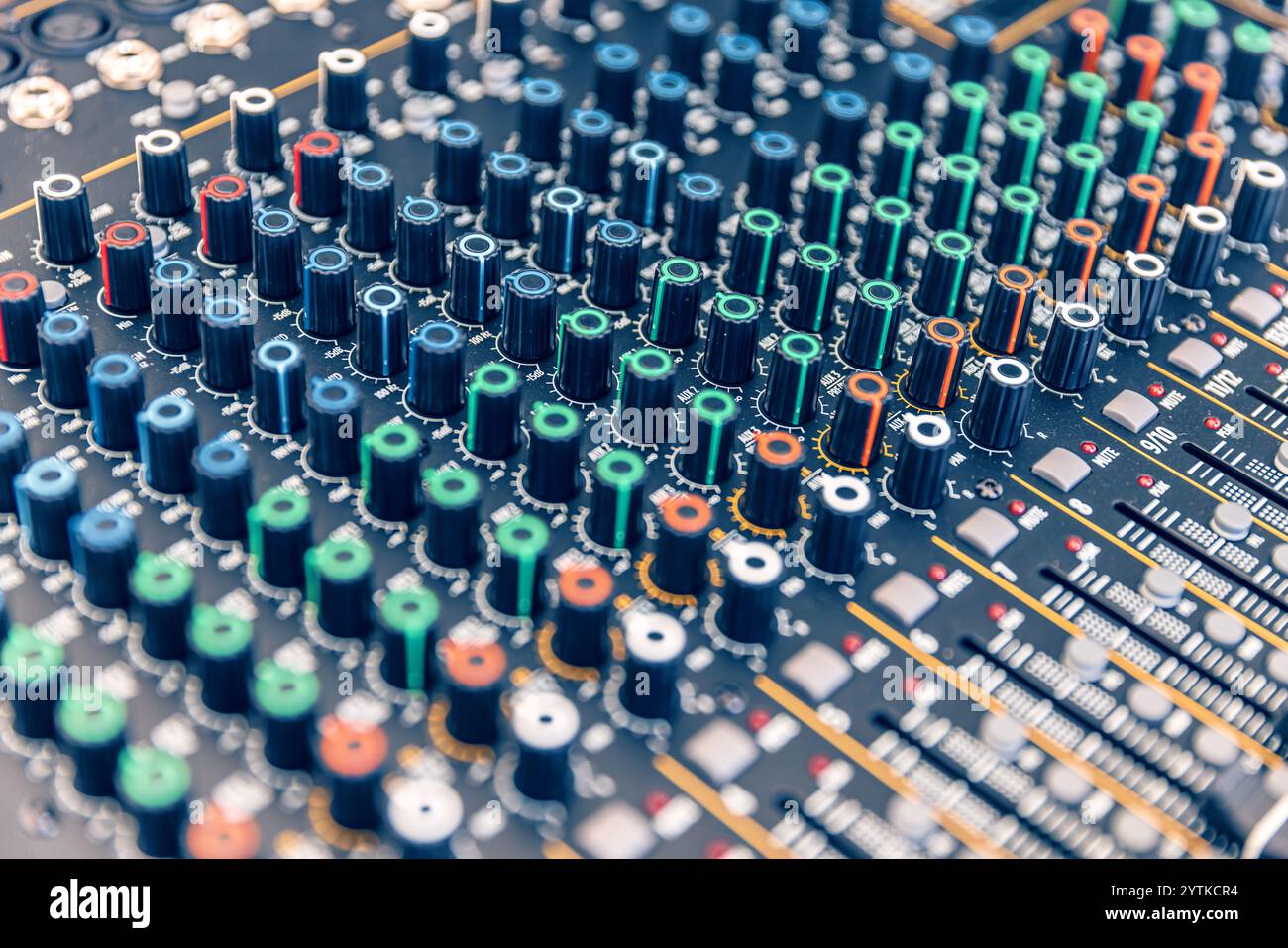 Nahaufnahme einer Mischkonsole mit zahlreichen Knöpfen und Fadern, ideal für Musikproduktionen oder Live-Sound-Engineering Stockfoto