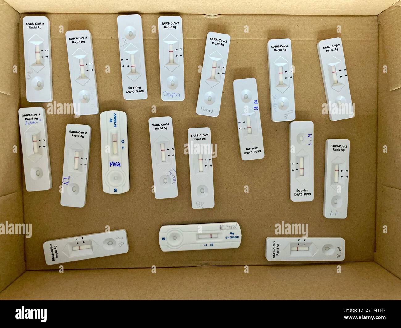 Ein Karton mit 18 negativen COVID-19-Tests mit Namen oder darauf, ein Symbol für Tests vor dem Unterricht in deutschen Schulen während der Corona-Pandemie Stockfoto