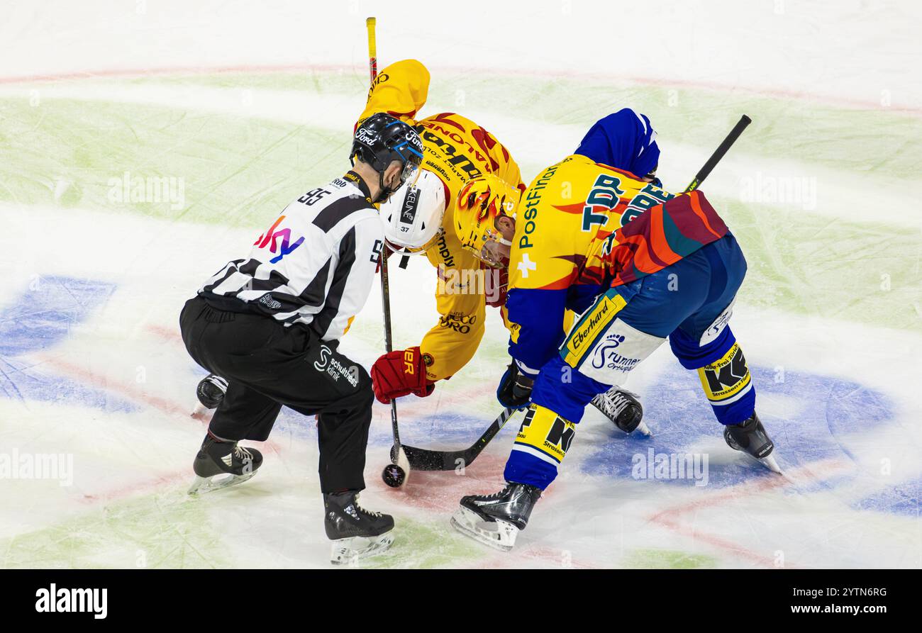 Kloten, Schweiz, 30. Nov 2024: Linienmänner #95 Sandro Gurtner wirft den Puck beim Auftritt zwischen #37 Sean Malone (Langnau) und Top-Score ein Stockfoto