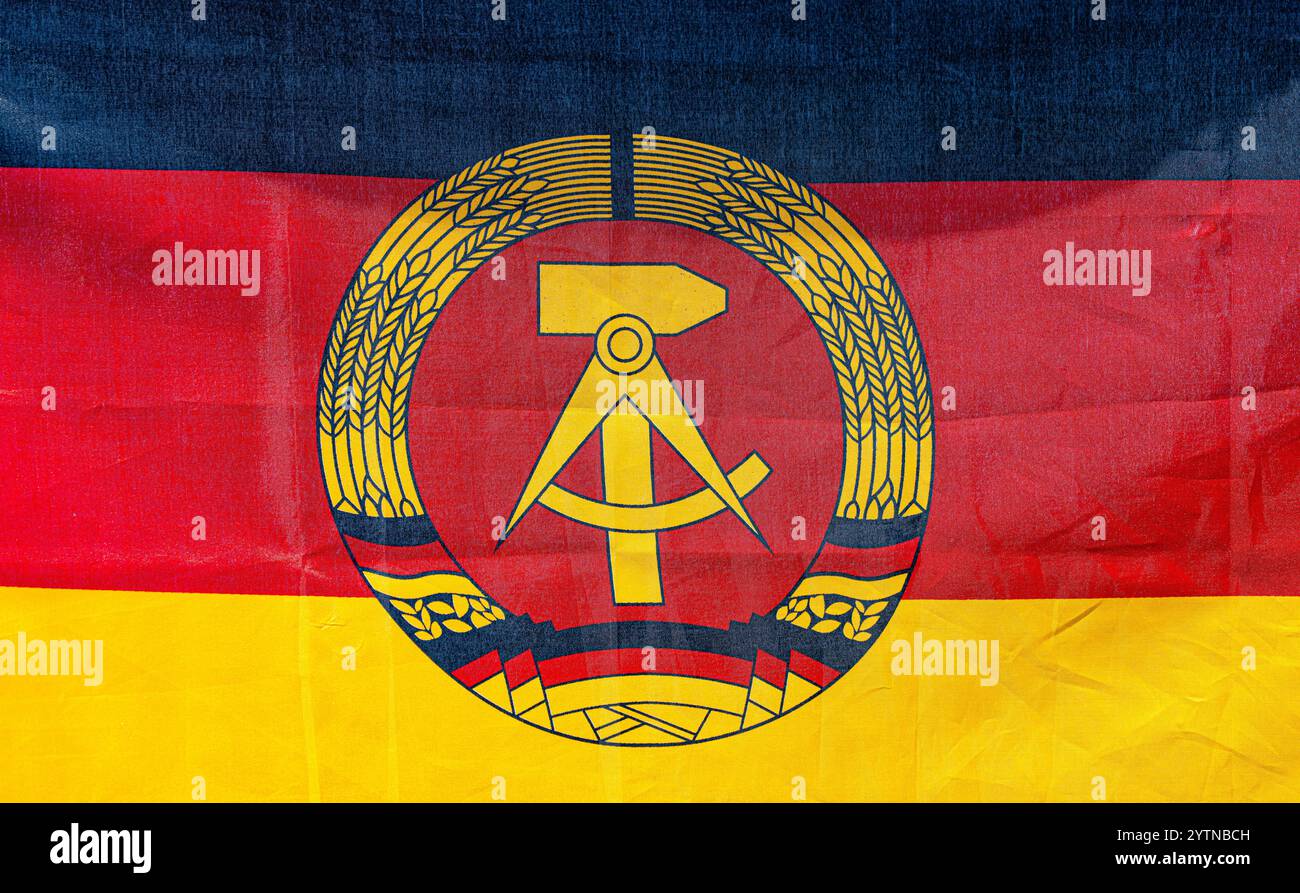 Hüntwangen, Schweiz, 24. August 2024: Die Flagge der DDR mit Hammer, Kompass und Weizenkranz in Schwarz, Rot und Gold. Stockfoto